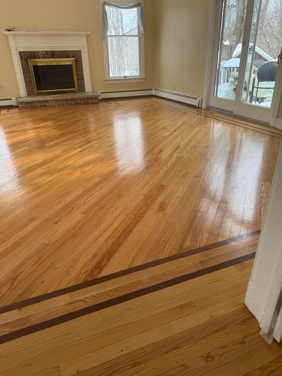 Living room oak floor with a dark inlay border and a fireplace