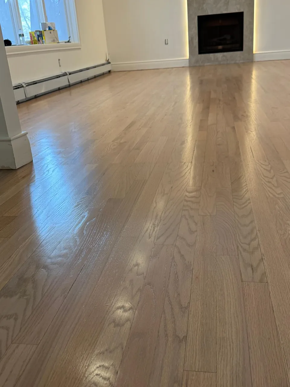 Living room with a fireplace and a refinished oak floor in a light natural finish